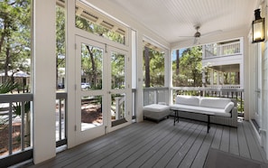 A covered porch with a white bench and a ceiling fan. - 287 W Lake Forest Dr - WaterColor Home (Santa Rosa Beach)
