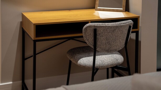 A wooden desk with a chair in front.