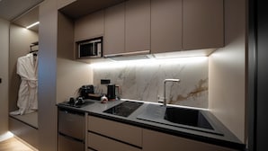 A modern kitchen with built-in appliances, a microwave, and a sleek faucet.