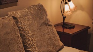 Un lit avec des coussins à motifs et une lampe de chevet.