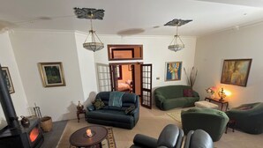 Un salon avec une cheminée, des canapés, une table basse et des œuvres d’art accrochées aux murs.
