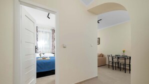 Una habitación de hotel con una cama, una pequeña mesa con sillas y un rincón comedor.