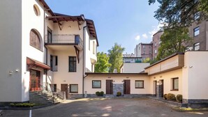 Un patio con un camino empedrado, una escalera que lleva a un balcón y un edificio con un balcón y una puerta marcada con el número 15.