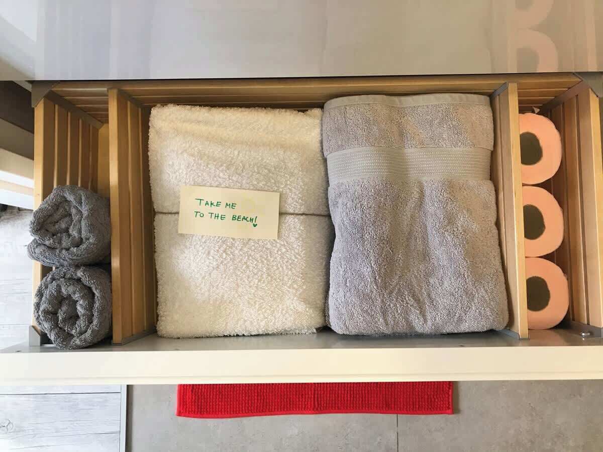 Un espacio de almacenamiento con toallas y una nota en una de ellas.