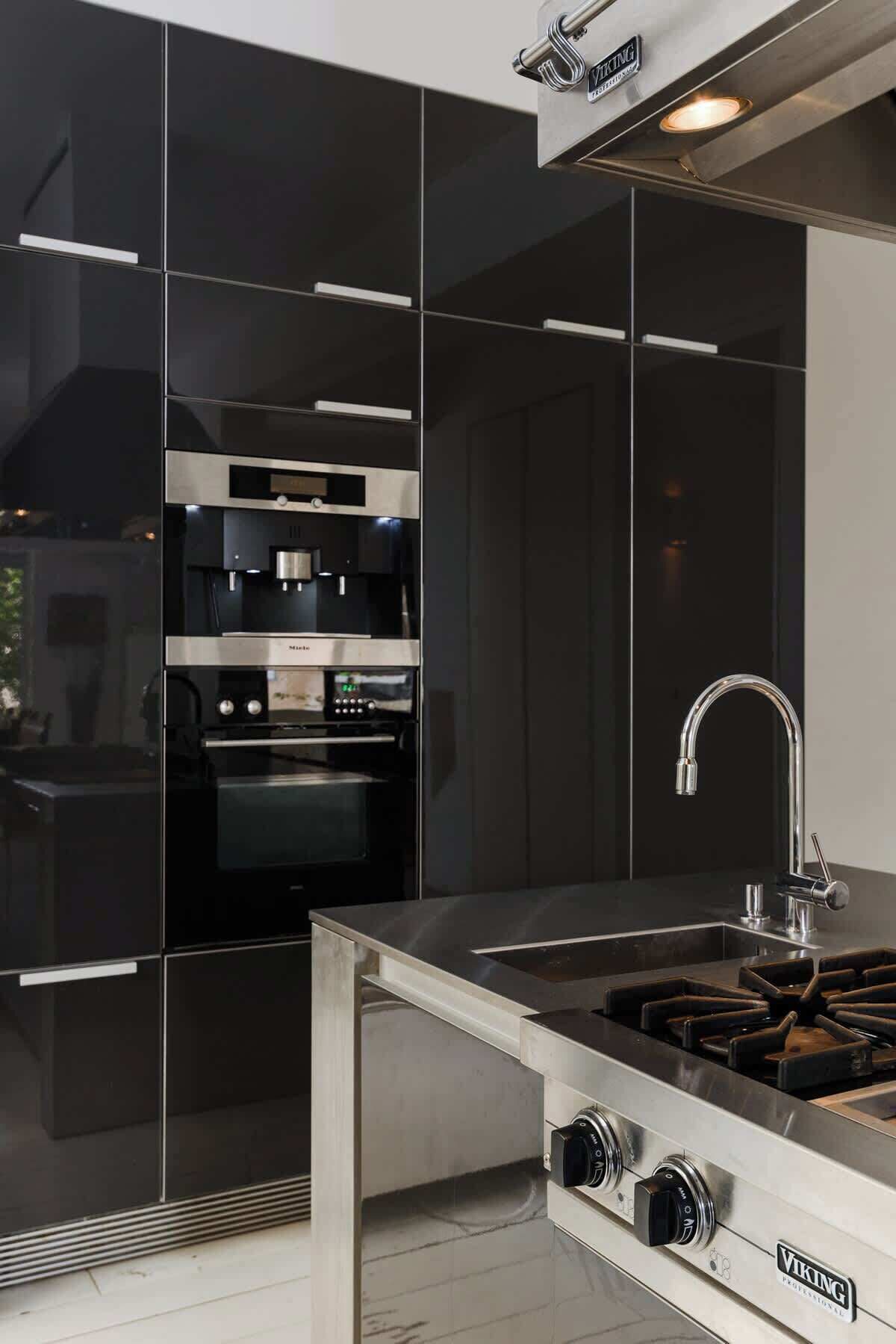 A modern kitchen with a stainless steel range hood, a built-in oven, and a gas stove.