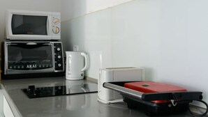 Een kitchenette met een magnetron, broodrooster en koffiezetapparaat.