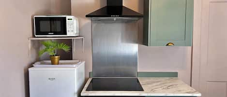 Una cocina compacta con microondas, estufa y lavaplatos.
