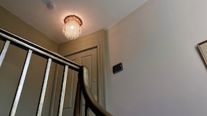 Un escalier muni d’une rampe métallique mène à une porte sur laquelle est apposée une plaque indiquant « Appartements du centre-ville ».