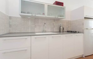 Eine Küche mit Spülbecken aus Edelstahl, einem modernen Wasserhahn und einem eingebauten Backofen.