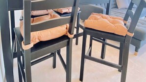 Ein Essbereich mit Tisch, Stühlen, einer Kronleuchter und einem Sofa.