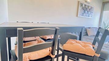 Un espace repas comprenant une table et des chaises, un lustre et un canapé.