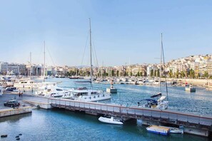 Un puerto deportivo con barcos amarrados, un muelle y un paisaje urbano al fondo.