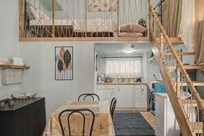 A compact living space with a loft bedroom, a dining area, and a kitchen. - Maria's Nest Studio in an Ideal Central Athens Location (Athens)