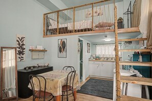 A loft-style room with a dining area, kitchen, and a loft bed. - Maria's Nest Studio in an Ideal Central Athens Location (Athens)