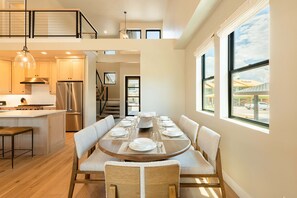 Una cocina moderna con zona de comedor, suelo de madera y vistas al exterior.