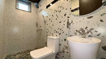 Een badkamer met toilet, wastafel en douche.