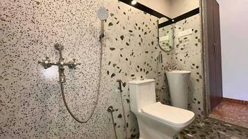 Un baño con inodoro, lavamanos y ducha.