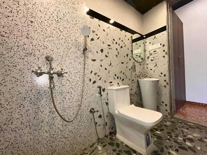 A bathroom with a toilet, sink, and shower. - Coastal Palm (Alibag)