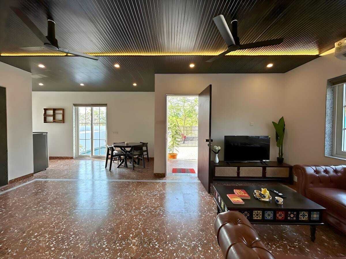 A spacious living area with a dining table, a sofa, and a television.