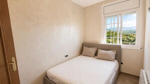 Una camera da letto con un letto, una finestra vista e un termosifone.