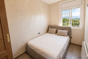 Ein Schlafzimmer mit Bett, einem Fenster mit Blick und einer Heizung.