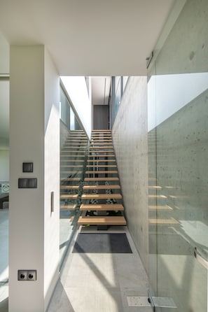 Ein modernes Interieur mit einer Glastreppe, die zu einer höheren Ebene führt.