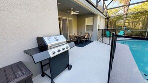 An outdoor patio with a grill, a pool, and a covered seating area. - Peaceful & Modern Retreat - Pool & Themed Rooms! (Davenport)