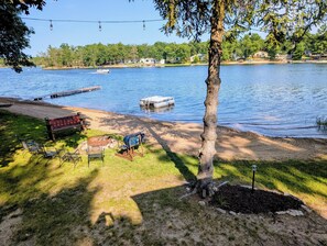 A lakeside view with a dock, a bench, and a fire pit area. - Escape to the Lake- Cozy Lakefront Family Retreat (National City)