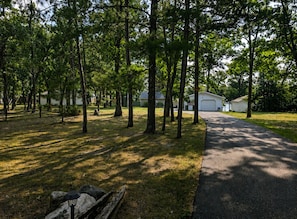 A paved pathway leading to a row of houses with a grassy area and trees in the foreground. - Escape to the Lake- Cozy Lakefront Family Retreat (National City)