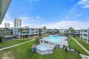 A hotel with a swimming pool, multiple balconies, and a view of surrounding buildings. - Sea Oats Condo With Beach and Bay Access (Gulf Shores)