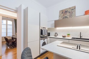 A modern kitchen with a built-in oven, microwave, and coffee maker. - Churchkey by Rent All Como (Como)