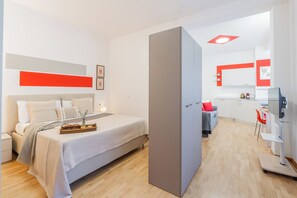 Ein modernes Hotelzimmer mit Bett, Nachttisch und Frühstückswagenset.