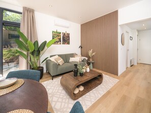 Una sala de estar moderna con un sofá, una mesa de centro y una planta grande.