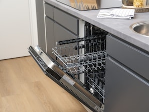 A modern kitchen with grey cabinetry, a dishwasher, and a sink.