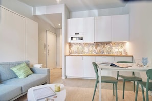 A modern apartment with a kitchenette, a dining area, and a living space. - Mare e Conchiglie (Albenga)