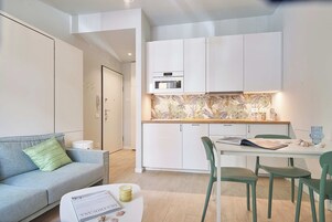 A modern apartment with a kitchenette, a dining area, and a living space.