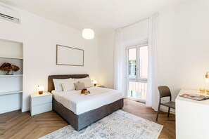 A modern bedroom with a bed, bedside tables, a desk, and a window with curtains. - The Monti Residence (Como)