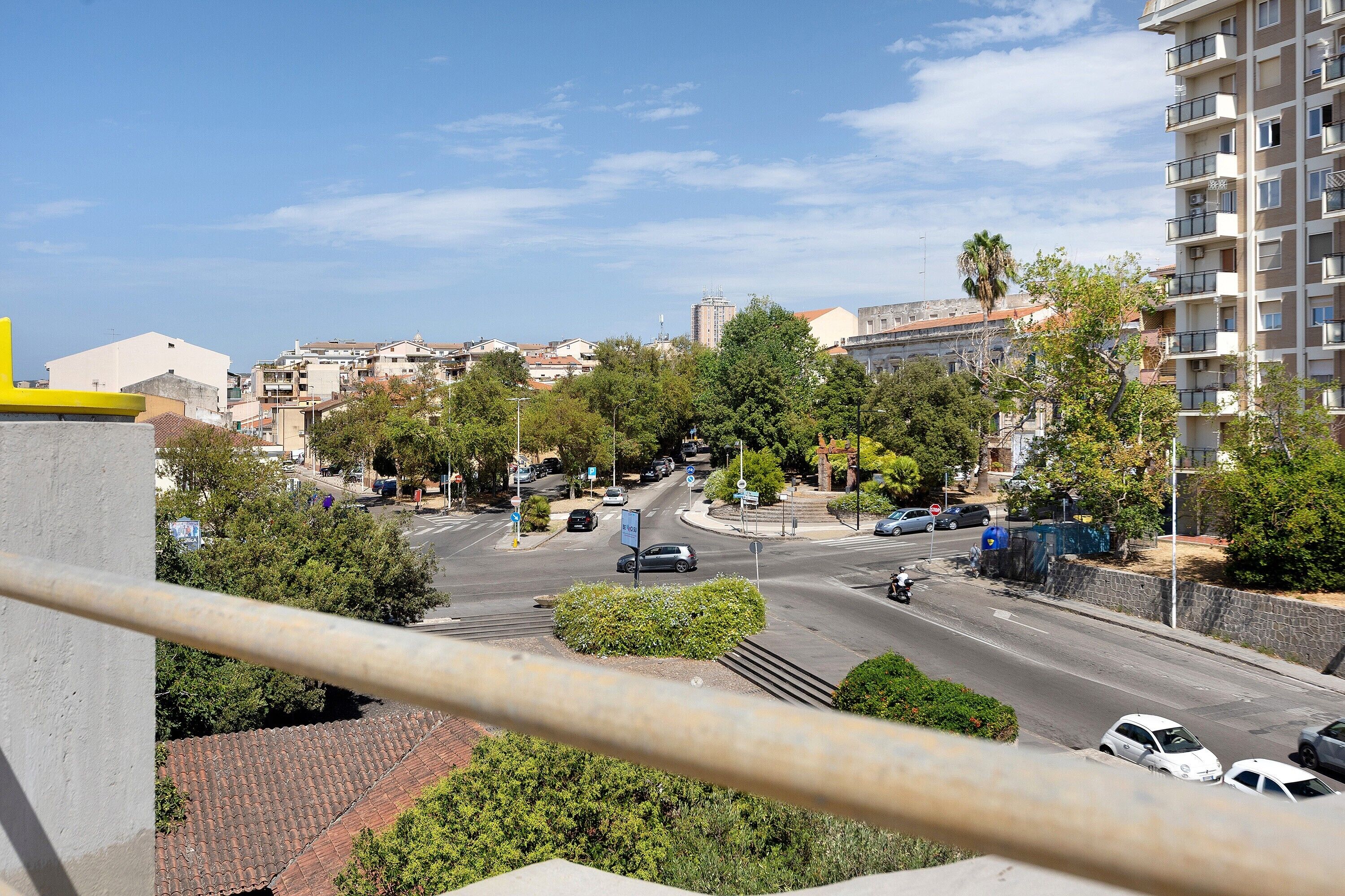 Una calle urbana con edificios, árboles y automóviles estacionados.