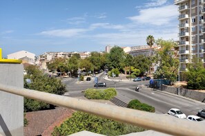Eine Stadtstraße mit Gebäuden, Bäumen und parkenden Autos.