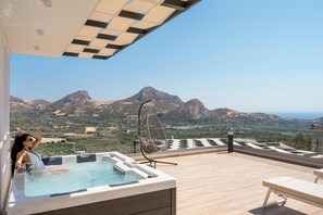A hot tub on a wooden deck with a mountain view. - Sirocco Lux Villas (Agios Vasileios)
