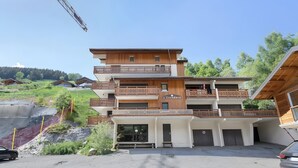 A multi-story building with balconies, a garage, and a sign reading 'L'Etendard.' - Apartment “Les Deux Alpes” with Mountain View, Balcony, and Wi-Fi (Les Deux Alpes)