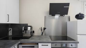 Une cuisine moderne équipée d’une machine à café, d’un four encastré et d’un four à micro-ondes.