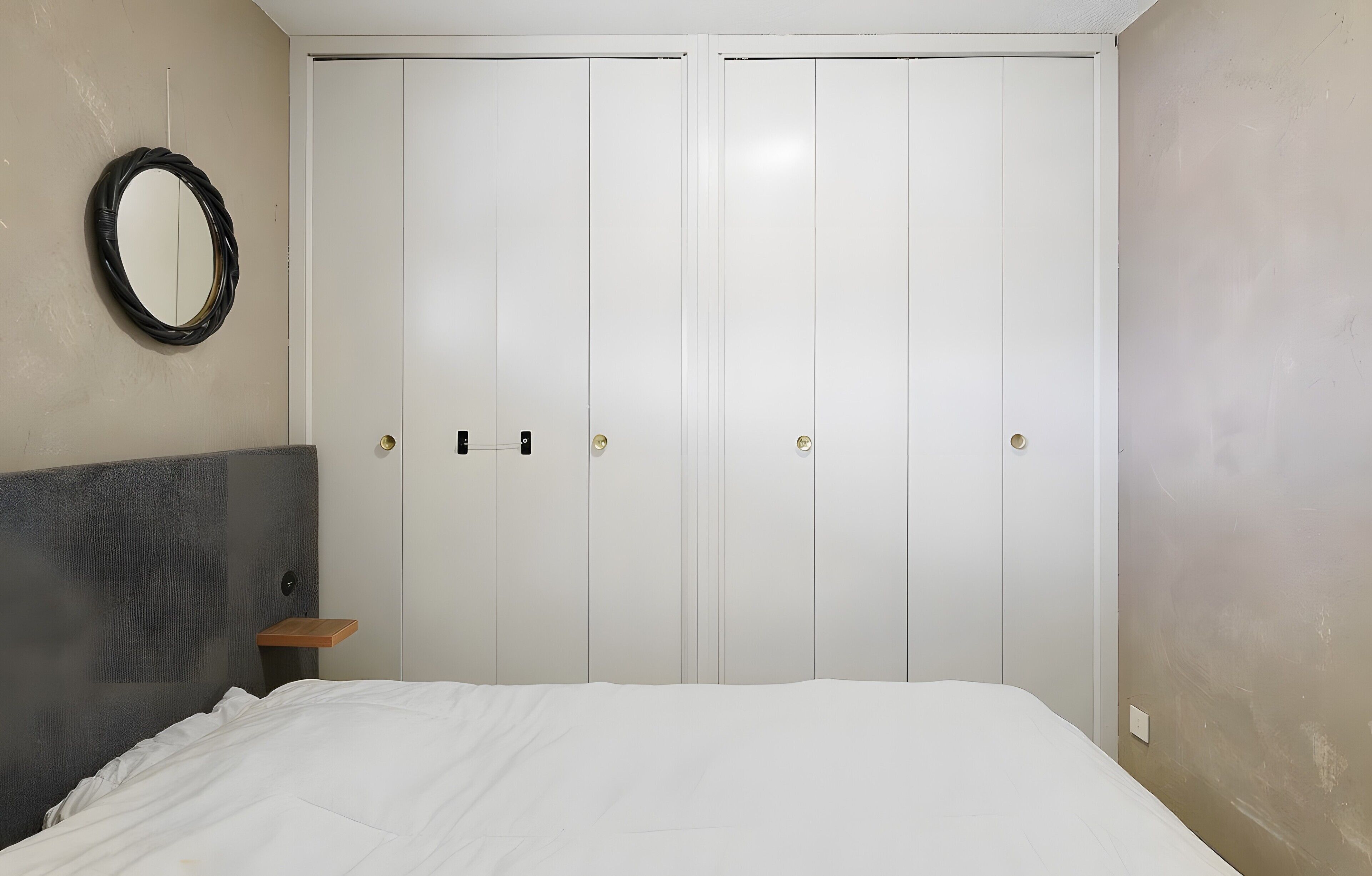 Une chambre à coucher avec un lit, une armoire et un miroir.