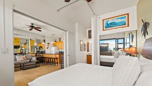 A hotel room with a large bed, a kitchenette, a dining area, and a living room. - Waikiki Banyan, Top Floor Oceanview Pool + Parking (Honolulu)