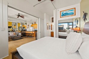 A hotel room with a large bed, a kitchenette, a dining area, and a living room. - Waikiki Banyan, Top Floor Oceanview Pool + Parking (Honolulu)