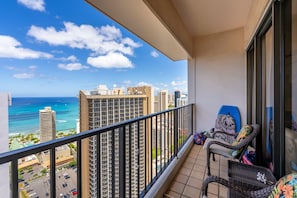 Uma varanda com vista para o oceano e edifícios altos.