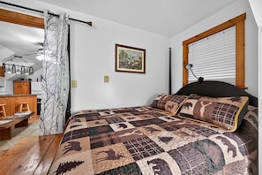 A bedroom with a bed, a desk, and a window with blinds. - Near Gettysburg | History, Trails & Dogs (Orrtanna)