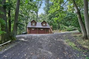 A cabin with a red garage, surrounded by trees and a gravel driveway. - Near Gettysburg | History, Trails & Dogs (Orrtanna)