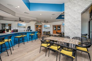 A modern restaurant with blue and white decor, wooden tables and chairs, and a bar area. - Ocean front at Ocean reef resort, waterpark, beach (Myrtle Beach)