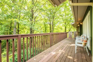 A wooden deck with a railing overlooking a forested area. - Smoky Mtn Home with Theater, Game Room & Hot Tub (Sevierville)